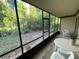 Screened-in porch overlooking lush greenery with a table and chairs at 170 Palmetto Woods Ct # 1A, Deltona, FL 32725