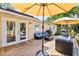 Back deck featuring patio seating, a barbeque, umbrellas for shade, and access to the home through french doors at 17409 Division St, Montverde, FL 34756