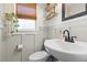 Neutral toned powder room featuring a modern black faucet and bright lighting, located on the main floor at 17409 Division St, Montverde, FL 34756