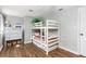 Bright bedroom featuring bunk beds, a large dresser, wood-look floors, and ample space for children at 17409 Division St, Montverde, FL 34756