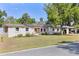 Quaint single-story home with solar panels, an American flag, carport and mature trees at 17409 Division St, Montverde, FL 34756
