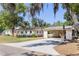 Charming single-story home with a spacious driveway, carport, and mature trees offering shade at 17409 Division St, Montverde, FL 34756
