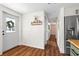 Bright hallway with wood floors leading to the front door, complete with coat rack and view of the backyard at 17409 Division St, Montverde, FL 34756