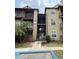 Condominium building featuring stairs leading to upper units, tropical landscaping, and accessible entrance at 208 Afton Sq # 307, Altamonte Springs, FL 32714