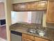 Well-lit kitchen with stainless steel sink, dishwasher, and granite countertop offers an inviting view into the living room at 208 Afton Sq # 307, Altamonte Springs, FL 32714