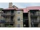 Multi-story condo building with red metal roof and private balconies on each level at 224 Afton Sq # 301, Altamonte Springs, FL 32714