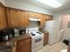 Well-lit kitchen with wooden cabinets, granite countertops, and white appliances at 224 Afton Sq # 301, Altamonte Springs, FL 32714