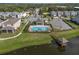 Scenic aerial shot of community pool and dock by a tranquil pond in a residential neighborhood at 2264 Emerald Springs Dr, Apopka, FL 32712