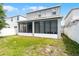 Backyard view of a two-story home featuring a screened-in patio area and a grassy yard at 2264 Emerald Springs Dr, Apopka, FL 32712
