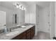 Bathroom featuring double sinks, granite counters, wood cabinets and large mirror at 2264 Emerald Springs Dr, Apopka, FL 32712