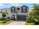Charming two-story home features a two-car garage, brick paver driveway, and inviting covered porch at 2264 Emerald Springs Dr, Apopka, FL 32712