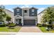 Charming two-story home features a two-car garage, brick paver driveway, and inviting covered porch at 2264 Emerald Springs Dr, Apopka, FL 32712