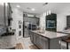 Bright kitchen features gray cabinets, stainless appliances, a granite island with seating and seamless transition to adjacent living spaces at 2264 Emerald Springs Dr, Apopka, FL 32712
