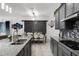 Beautiful kitchen featuring gray cabinets, mosaic backsplash, and an island that connects to a dining area with a sliding barn door at 2264 Emerald Springs Dr, Apopka, FL 32712