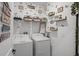 Well-organized laundry room with washer, dryer, shelving, and decorative wall art at 2264 Emerald Springs Dr, Apopka, FL 32712