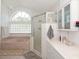 Well-lit bathroom featuring a tub, glass shower, and cabinets at 23 Old Sunbeam Dr, South Daytona, FL 32119