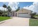 Charming single-story home featuring a two-car garage, well-manicured lawn and mature palm trees, located in a serene neighborhood at 23 Old Sunbeam Dr, South Daytona, FL 32119