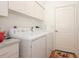 Well-lit laundry room featuring a washer, dryer, and ample overhead cabinet storage at 23 Old Sunbeam Dr, South Daytona, FL 32119