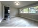 Bedroom features a large window, light gray walls, and light wood-look floors with an entrance to another room at 232 W Lafayette St, Winter Garden, FL 34787