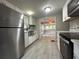 This kitchen features stainless steel appliances, white cabinets, and modern flooring with a view to the living room at 232 W Lafayette St, Winter Garden, FL 34787