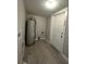 Utility room featuring a water heater, light gray walls, and light wood-look floors with a back door at 232 W Lafayette St, Winter Garden, FL 34787
