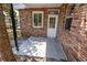 Rear porch with new gray tile, white door with glass, and brick facade at 237 W Mcclendon St, Lady Lake, FL 32159