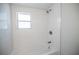 This bathtub showcases a modern shower head and white tile at 237 W Mcclendon St, Lady Lake, FL 32159