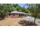 Lovely brick home with a carport, lush trees and a mulched garden bed at 237 W Mcclendon St, Lady Lake, FL 32159