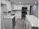 Modern kitchen with white cabinets, stainless steel appliances, and stylish backsplash at 237 W Mcclendon St, Lady Lake, FL 32159