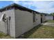 Angle shot of the exterior featuring cinder block walls and boarded-up windows at 2467 Myakka Dr, Orlando, FL 32839