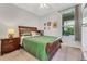 This bedroom features a wood bed frame, green bedding, and bright natural light from the nearby window at 2609 Dinville St, Kissimmee, FL 34747
