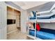 Bunk bedroom featuring a closet with shelving, TV, neutral carpet, and ladder to the top bunk for children at 2609 Dinville St, Kissimmee, FL 34747