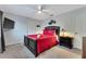 Comfortable bedroom with red bedding, ceiling fan, wall-mounted TV, and stylish wall decor for a cozy atmosphere at 2609 Dinville St, Kissimmee, FL 34747