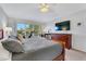 This bedroom features a dark wood bed frame, large window, and workspace near the window at 2609 Dinville St, Kissimmee, FL 34747