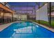 Backyard with a screen-enclosed pool, patio, lounge chairs, projector screen, and manicured green space at 2609 Dinville St, Kissimmee, FL 34747