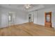 A spacious bedroom with light hardwood floors, white trim, and a view to other rooms at 288 Englenook Dr, Debary, FL 32713