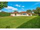 Expansive backyard featuring a large lawn, mature hedges, and a stucco house with sliding glass doors at 3108 Troy Dr, Orlando, FL 32806