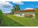 Beautiful backyard featuring lush green lawn, waterfront view, and a private dock with gazebo and kayaks at 3108 Troy Dr, Orlando, FL 32806