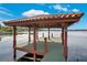 Waterfront gazebo featuring wood supports, peaked roof, decorative lighting, with water and distant shore views at 3108 Troy Dr, Orlando, FL 32806
