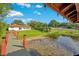 Backyard view from covered patio, featuring a dock, waterfront access and green lawn with mature landscaping at 3108 Troy Dr, Orlando, FL 32806