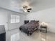 Bedroom with modern tile flooring, ceiling fan, window, and simple furnishings, enhanced by ample natural light at 3120 Ginger Cir, Orlando, FL 32826