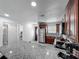 Open-concept kitchen with granite countertops and stainless steel appliances, leading to the front door at 3120 Ginger Cir, Orlando, FL 32826