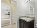 Bathroom with sink, vanity, mirror, and tile flooring. Arched doorway leads to kitchen at 3443 Berkshire Woods Ter, Deltona, FL 32725