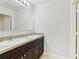 Modern bathroom featuring a double vanity with dark wood cabinets and a large mirror, exuding elegance at 3443 Berkshire Woods Ter, Deltona, FL 32725