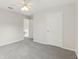 A spacious bedroom with neutral walls, ceiling fan, and a closed door at 3443 Berkshire Woods Ter, Deltona, FL 32725