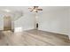 Bright living room featuring modern flooring, neutral walls, staircase, and an open archway to the back of the home at 3443 Berkshire Woods Ter, Deltona, FL 32725