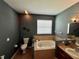 Bathroom featuring a soaking tub, tile surround, and dark wall paint at 3579 Maple Ridge Loop, Kissimmee, FL 34741