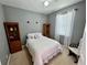 Cozy bedroom with neutral walls, white bedding, and ample natural light from the window at 3579 Maple Ridge Loop, Kissimmee, FL 34741