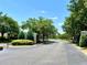A gated community entrance with lush landscaping and mature trees provides a secure and welcoming entry at 3579 Maple Ridge Loop, Kissimmee, FL 34741