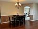 Formal dining room with hardwood floors features an elegant chandelier and classic chair rail molding at 3579 Maple Ridge Loop, Kissimmee, FL 34741